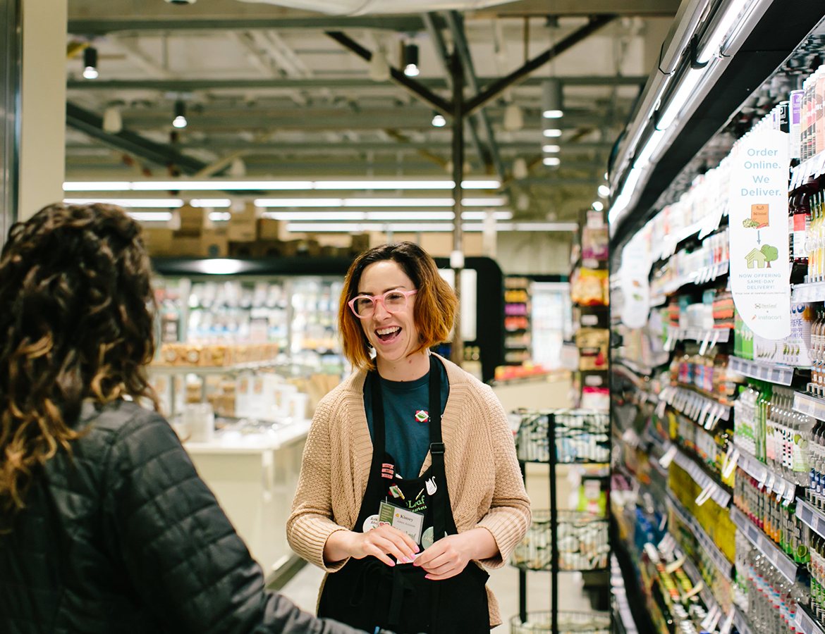 two women talking in the dairy section of a new leaf store